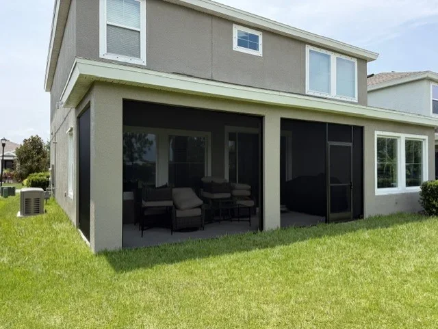 Black aluminum screen enclosure with mesh screening on residential home rear patio